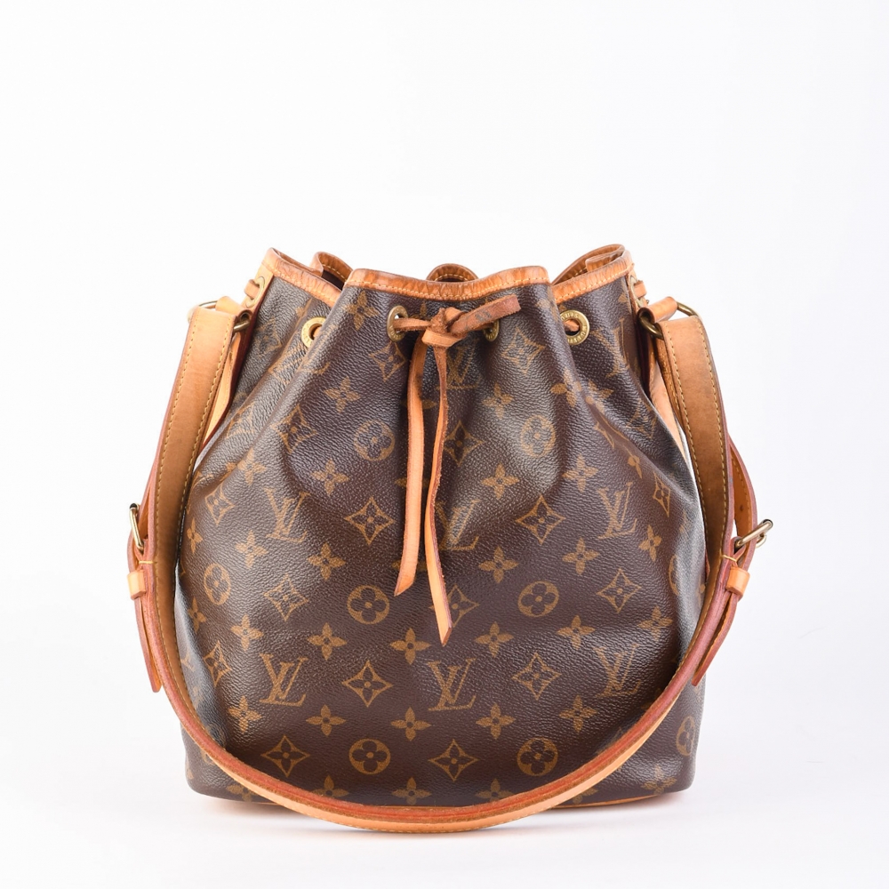 En tidløs og funksjonell bøtteveske fra Louis Vuitton – modellen Noé PM, laget i slitesterk brun monogram canvas med ekte skinn og gullfarget hardware. Vesken ble opprinnelig designet for å bære champagneflasker, men fungerer i dag som en stilig og romsli