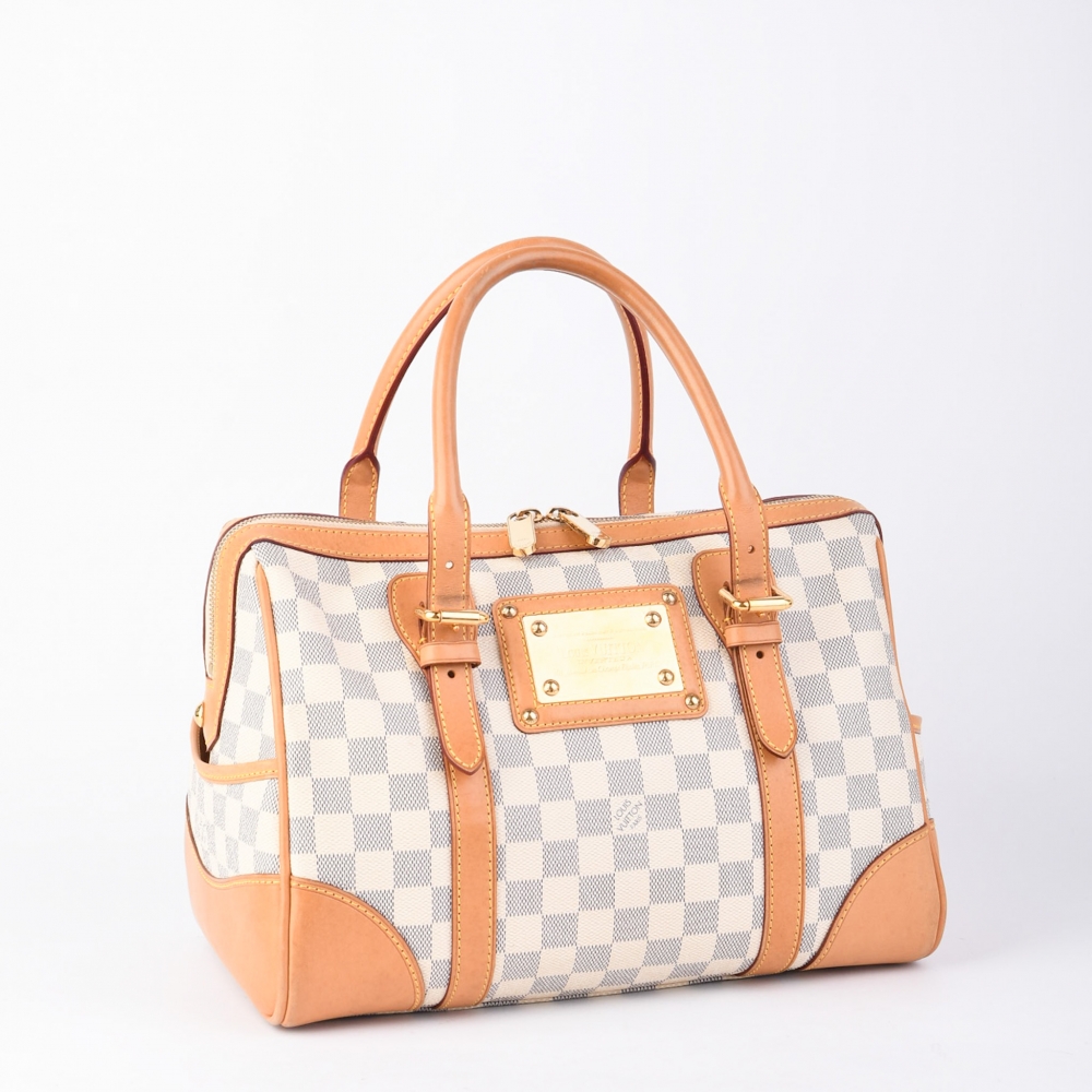 Louis Vuitton Berkeley i Damier Azur er en luksuriøs og romslig modell med strukturerte linjer og klassiske detaljer. Vesken er laget i Frankrike i 2009 og kombinerer det lyse og sommerlige Damier Azur-mønsteret med skinnende gulldetaljer og solide håndta